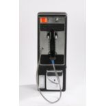 American wall mounted pay phone, with coin slot above handset and change return recess