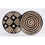 Two pottery plates one marked Americo Paz, Piura - Peru, Chulucanas. One decorated with a spiral the