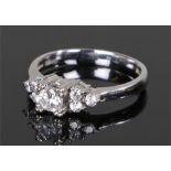 18 carat white gold and cubic zirconia ring, with a central round cut cubic zirconia flanked by