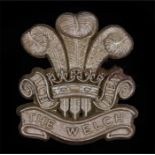 World War Two plastic economy cap badge to the Welsh Regiment, in light bronze, two blades to the