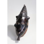 Fine African Guro mask, with a arched headpiece with line carved design above the arched eyes and