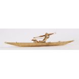 Inuit fisherman in sealskin canoe, the carved figure holding a harpoon, together with the stand