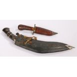 Indian Kukri, housed within the leather scabbard, together with a smaller knife with wooden scabbard