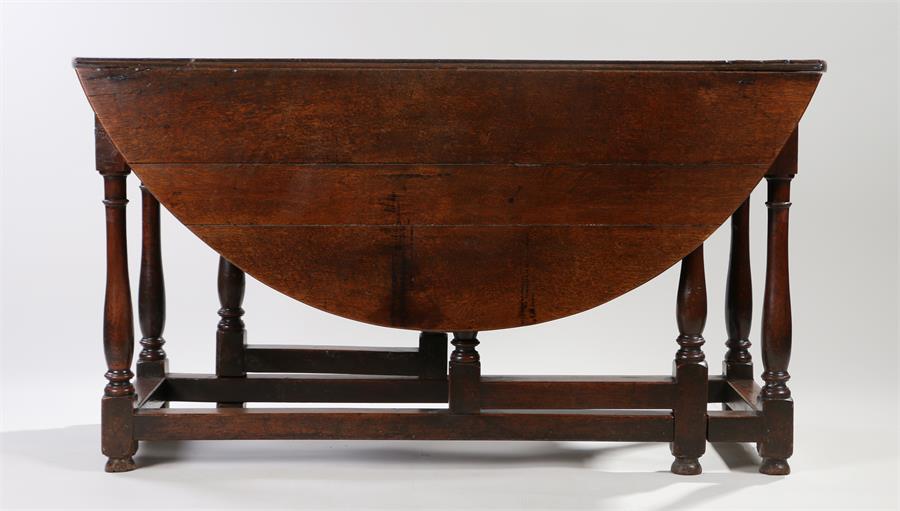 18th Century oak drop leaf table, the drop leaf oval top above a single frieze drawer and turned