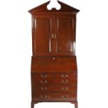 George III mahogany bureau bookcase, the swan neck pediment above a pair of panel doors enclosing