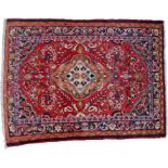 Persian rug, the red field with a yellow medallion and swirls of multi coloured flowers, four band