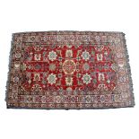 Persian rug, with rows of foliate style medallions and a red field, geometric boarders, 177cm x