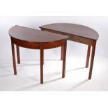 Pair of George III mahogany demi lune tables, the demi lune tops above deep friezes and moulded