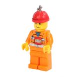 Ed Sheeran's Lego man keyring/torch, oversized form with orange body and red hat, torch to the feet.