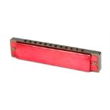 Ed Sheeran's harmonica, in red and bronze effect metal, worn and damaged . All of the Ed Sheeran