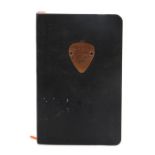Ed Sheeran's note pad, with a guitar pick to the front and the text Buy the ticket, take the ride.