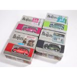 A set of 4 different commemorative tins each containing a different die-cast Beatles taxi, an unworn