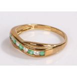 9 carat gold emerald set ring, with a row of emeralds to the wavy head, ring size Q