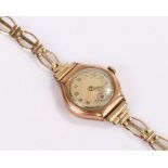 9 carat gold ladies wristwatch, with a silvered dial and gilt hours