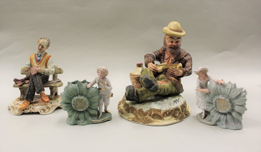 Capodimonte figure, of a man seated playing an instrument, together with another of a seated man and