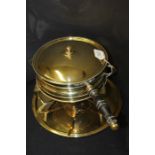 Brass pan and burner, the lidded pan with a turned handle above the tripod base and a brass tray,