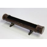 black lacquered pen tray, formed from a section of bamboo, with red scroll decoration, 30cm wide