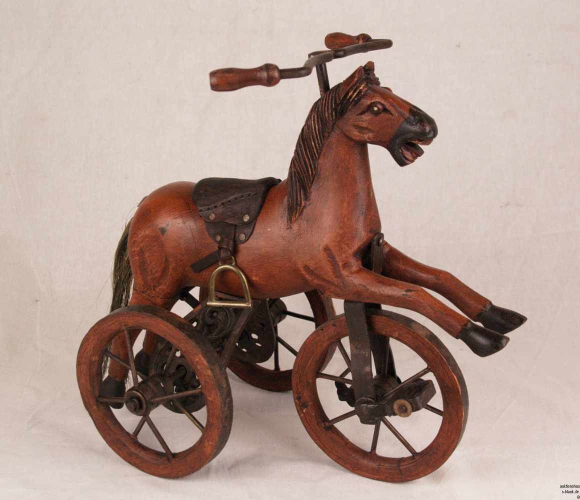 Modell-Dreirad-Pferd - Holz geschnitzt und bemalt, auf drei Eisenrädern, mit Lenkrad und zwei