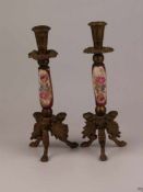 Paar Kerzenhalter - Messing/Porzellan, Stand mit drei stilisierten Harpyien, Balusterschaft aus