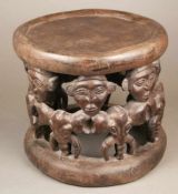Hocker - Kamerun, braunes Holz, geschnitzt, runde Sitzfläche, seitlich 7 Elefantenköpfe