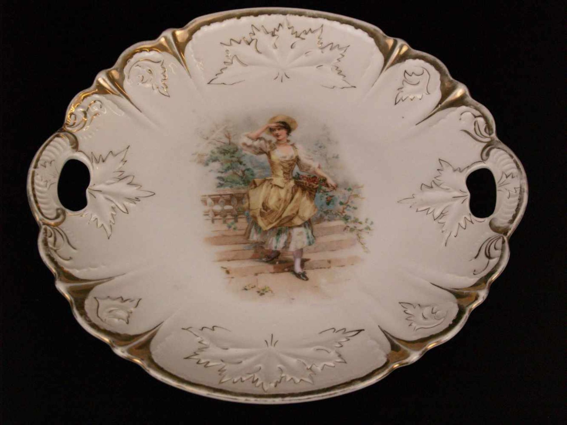 Zierteller - runder Teller mit zwei Handhaben, im Spiegel polychromer Dekor mit Dame auf einer
