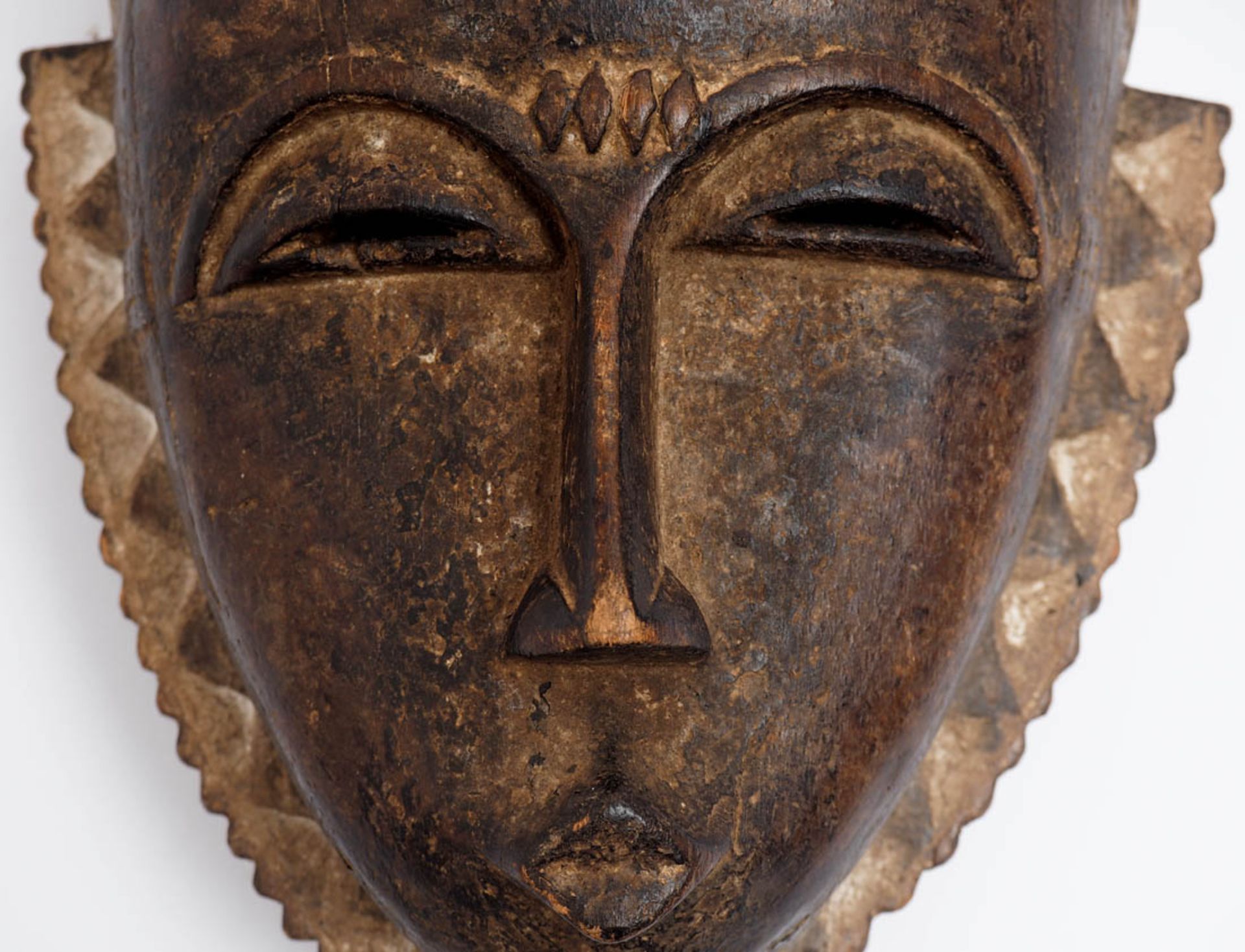 Maske, Baule, Elfenbeinküste In Form eines Kopfes mit stilisiertem Bart und reliefierter Frisur. - Bild 2 aus 4