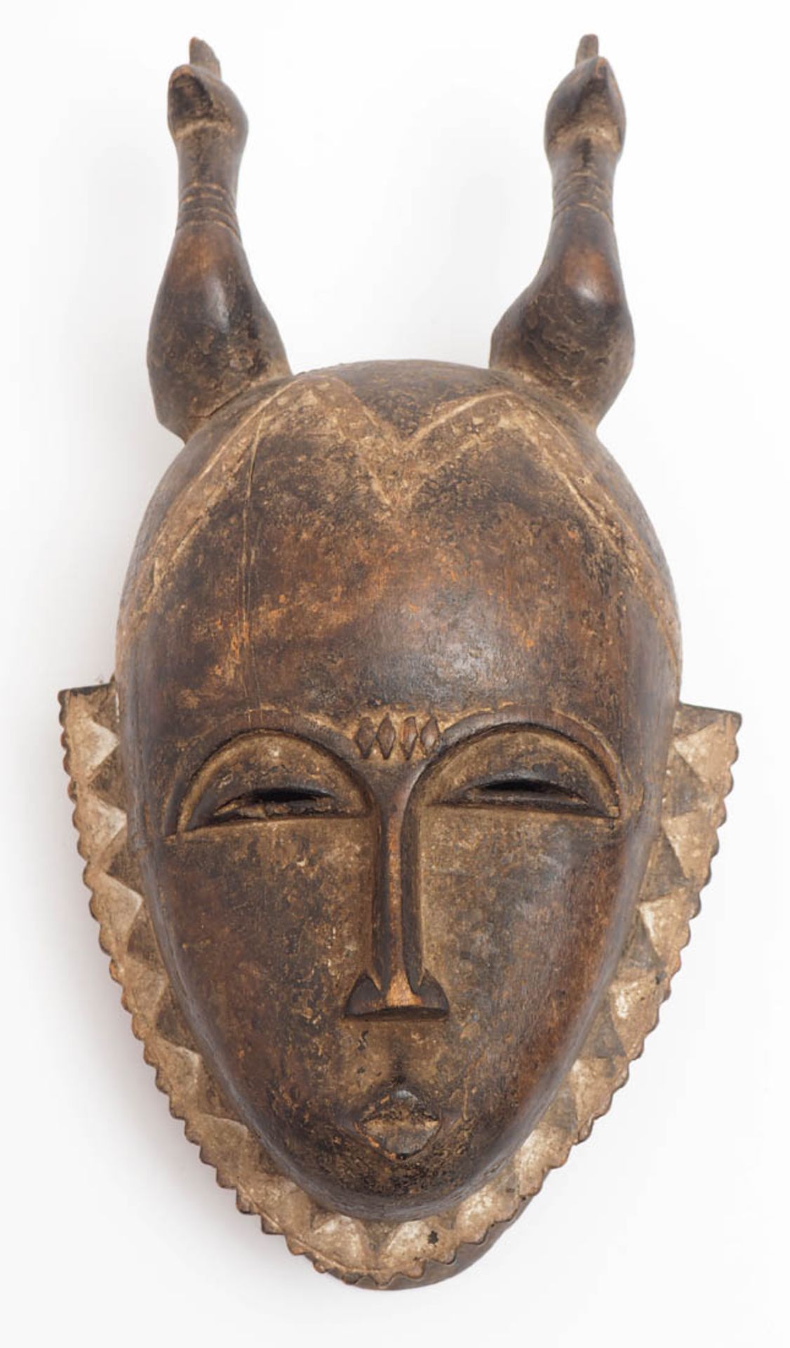 Maske, Baule, Elfenbeinküste In Form eines Kopfes mit stilisiertem Bart und reliefierter Frisur.