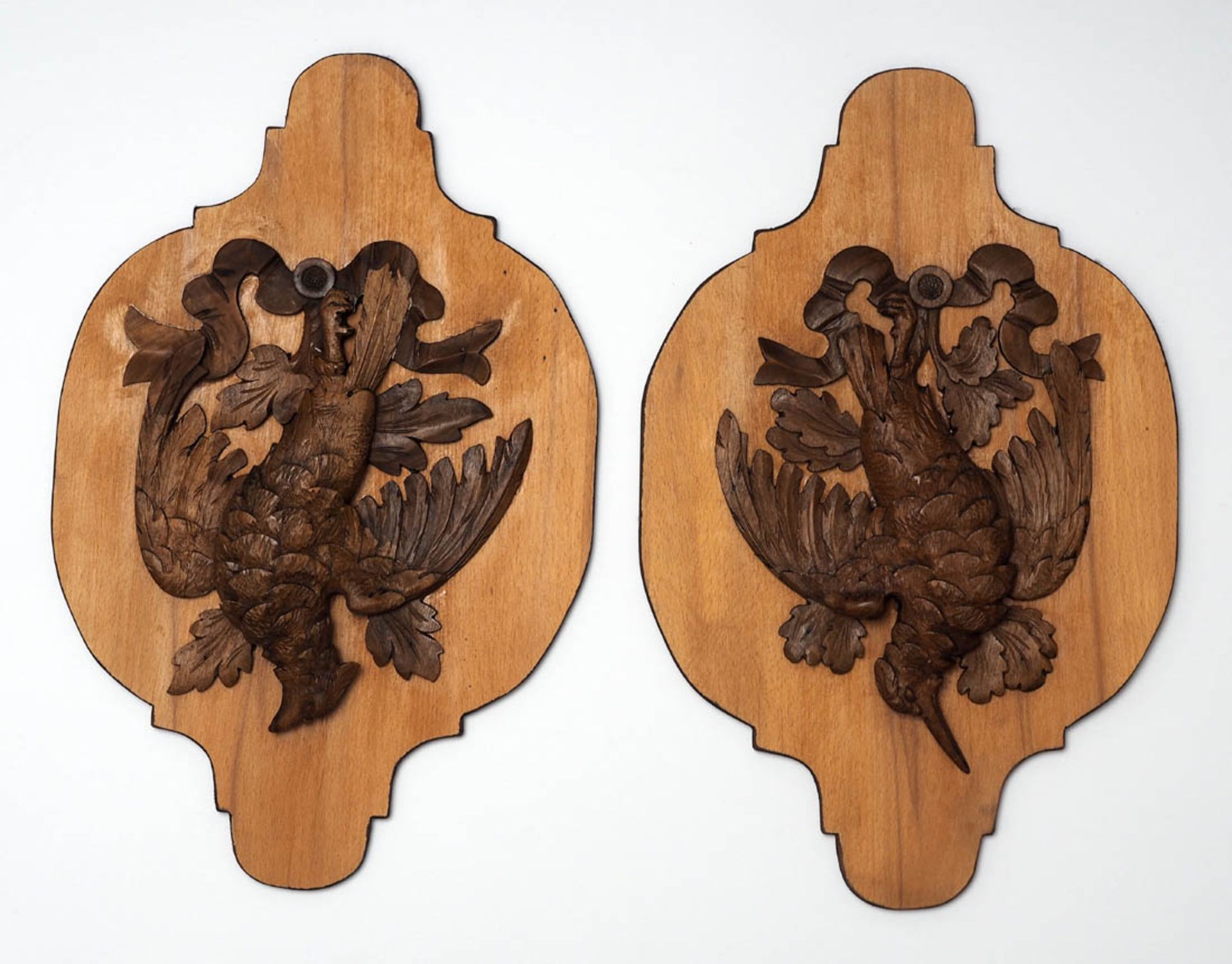 Paar Wandappliken Holz. Mehrfach eingezogene Form, darauf plastisch geschnitzte Jagdtrophäen
