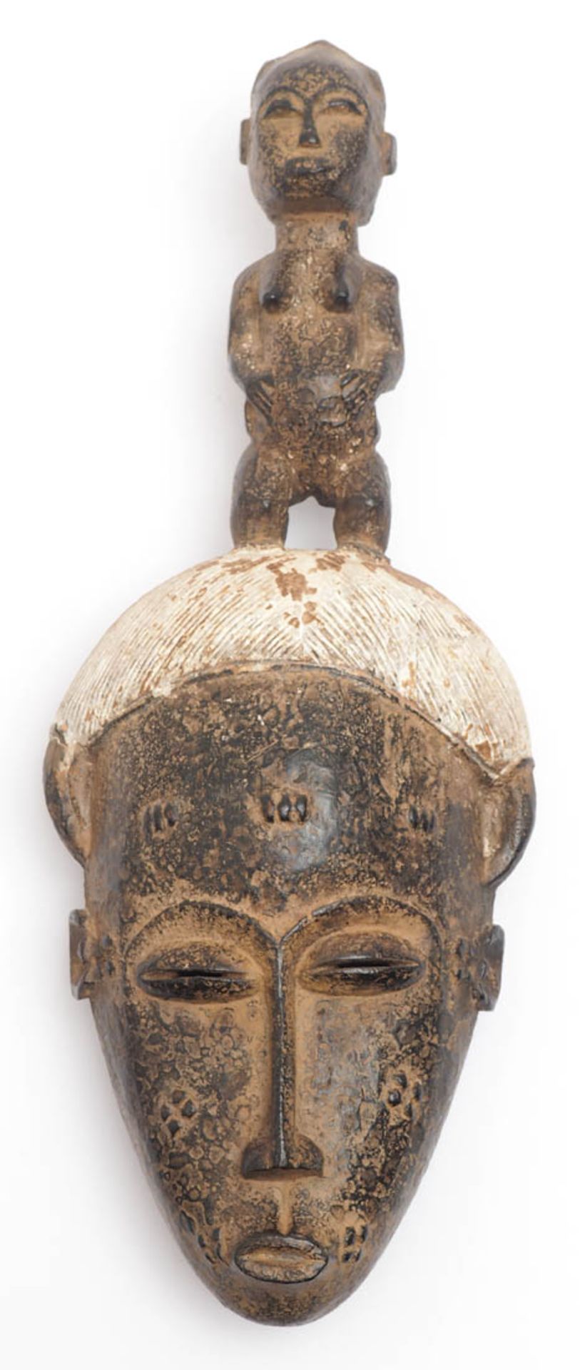 Maske, Baule, Elfenbeinküste Plastisch geformtes Gesicht mit reliefierten Verzierungen und Frisur.