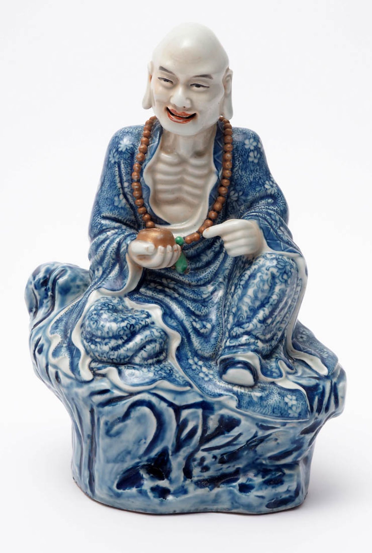 Figurine, China, Anfang 20.Jhdt. Auf einem Felsen sitzender buddhistischer Mönch, in seiner Hand