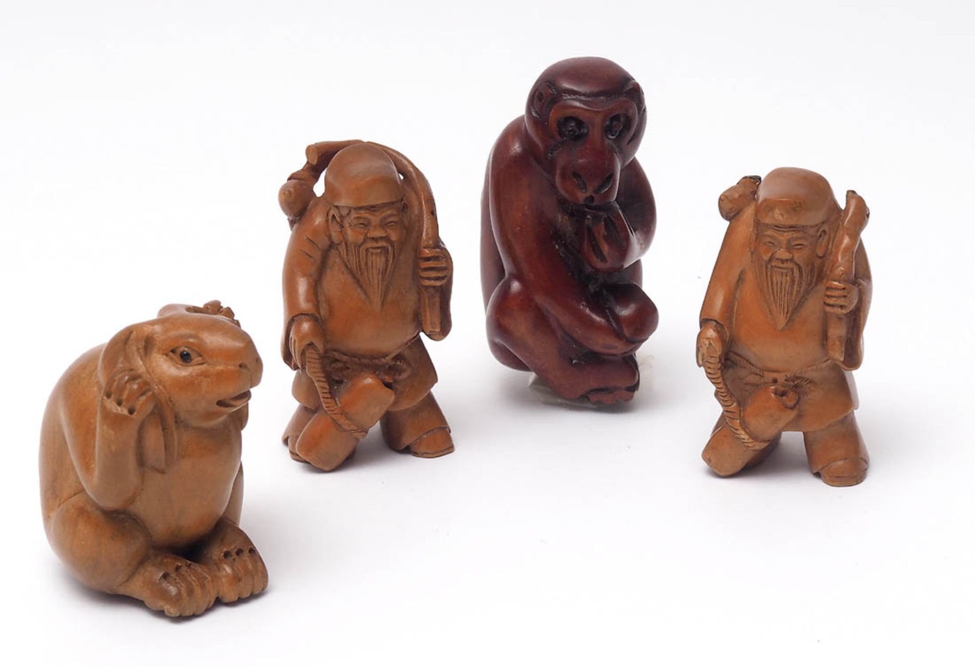 Vier Netsuke, Japan Sitzender Hase, zwei alte Herren mit Bündel und ein sitzender Affe. Buchsbaum,