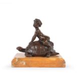 A patinated bronze sculpture of a putto on a turtle