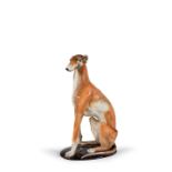 A polychrome sculpture of a sitting greyhound