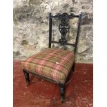 A Victorian nursing chair with tartan upholstery fitted with castor feet