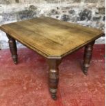 A solid oak dining table on turned legs & castor feet