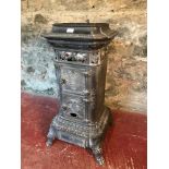 Vintage French wood burning stove with ornate design, supported on 4 claw feet
