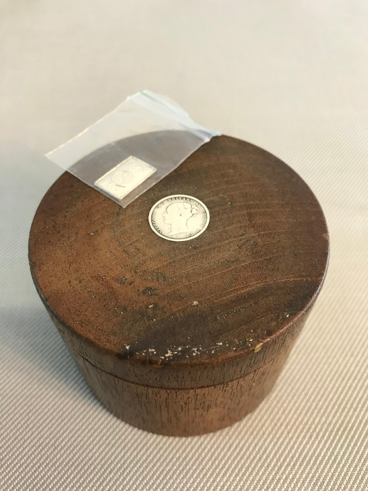 Wooden storage box fitted with silver coin to the top. Box measures 6x8cm. Together with 1 Gram fine