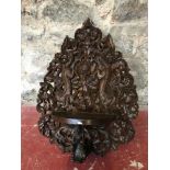 Indonesian Highly carved wall plaque with shelf to the centre of the carving, Has a kneeling