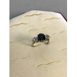 Platinum ladies ring set with a large blue sapphire and two 0.75 carat diamonds on each side.