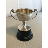 Birmingham silver two handled small trophy on hard wood stand. Makers William Neale & son Ltd. Dated