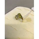 18ct gold ladies dress ring with green and clear stone setting. Weighs 4.32grams