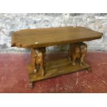 Solid wood 2 tier coffee table. Showing 2 large carved elephant figures as supports. Measures