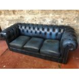 Blue chesterfield 3 seat settee. Damage to one cushion.