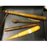 A vintage wooden truncheon, Victorian ruler, antique leather weapon and one other