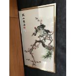 An oriental silk tapestry depicting cranes amongst blossom, signed by artist