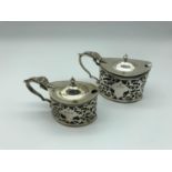 Two Birmingham silver condiment pots fitted with blue interior liners, makers Stewart Dawson & Co,