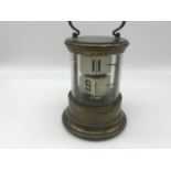 A 1930s Ever Ready Chronos ticket flip clock with cylindrical brass and glass case. Measures 16cm in