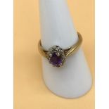 A 9ct gold ladies ring set with a Large centred Amethyst stone circled by diamonds. Size O. Weighs