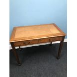 A Brown leather topped 2 drawer writing table. Measures 77x106x61cm