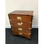 A Reproduction campaign chest of drawers. Fitted with brass fitments. Measures 61.5X46X30 cm